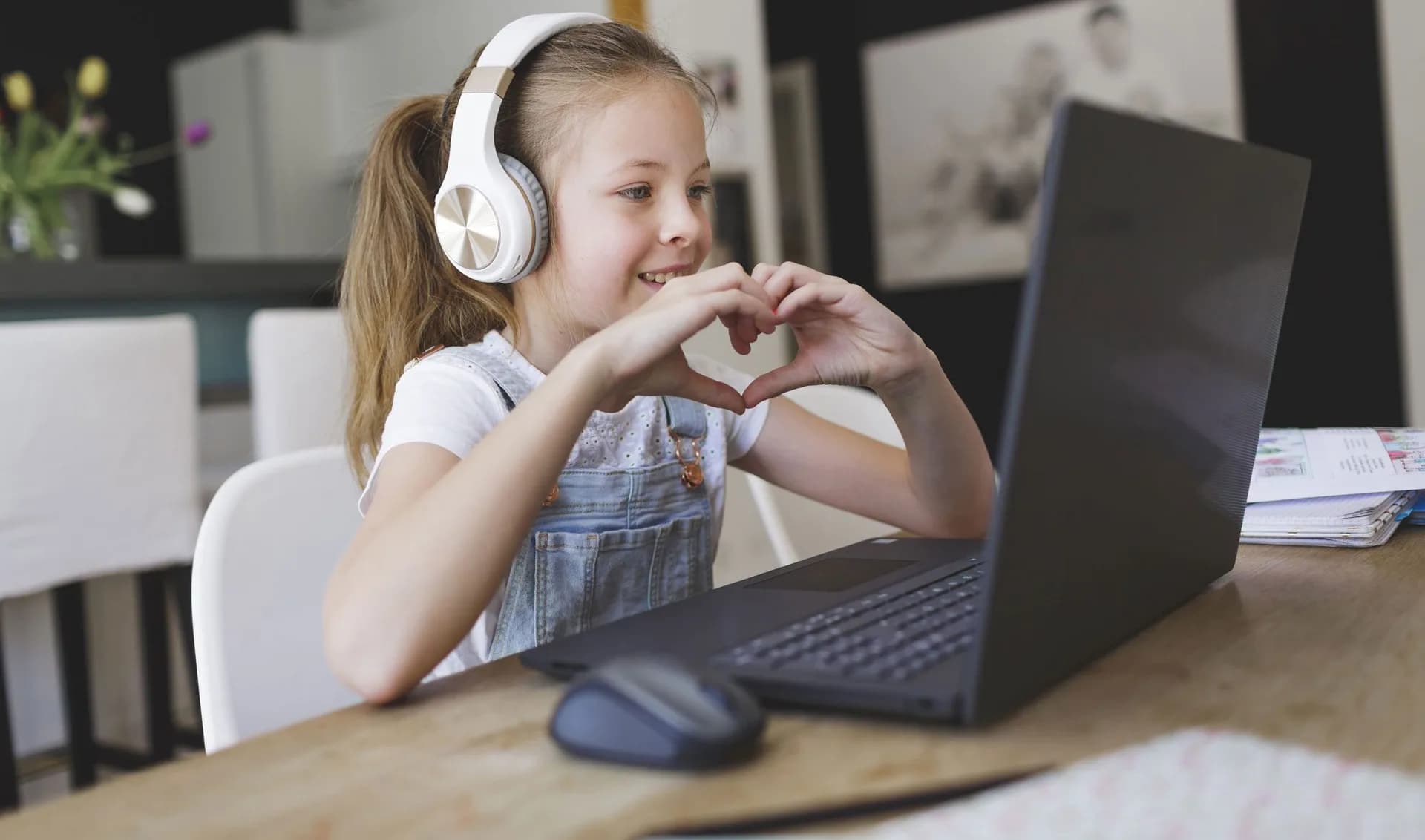 girl wearing headphones talking to someone via laptop