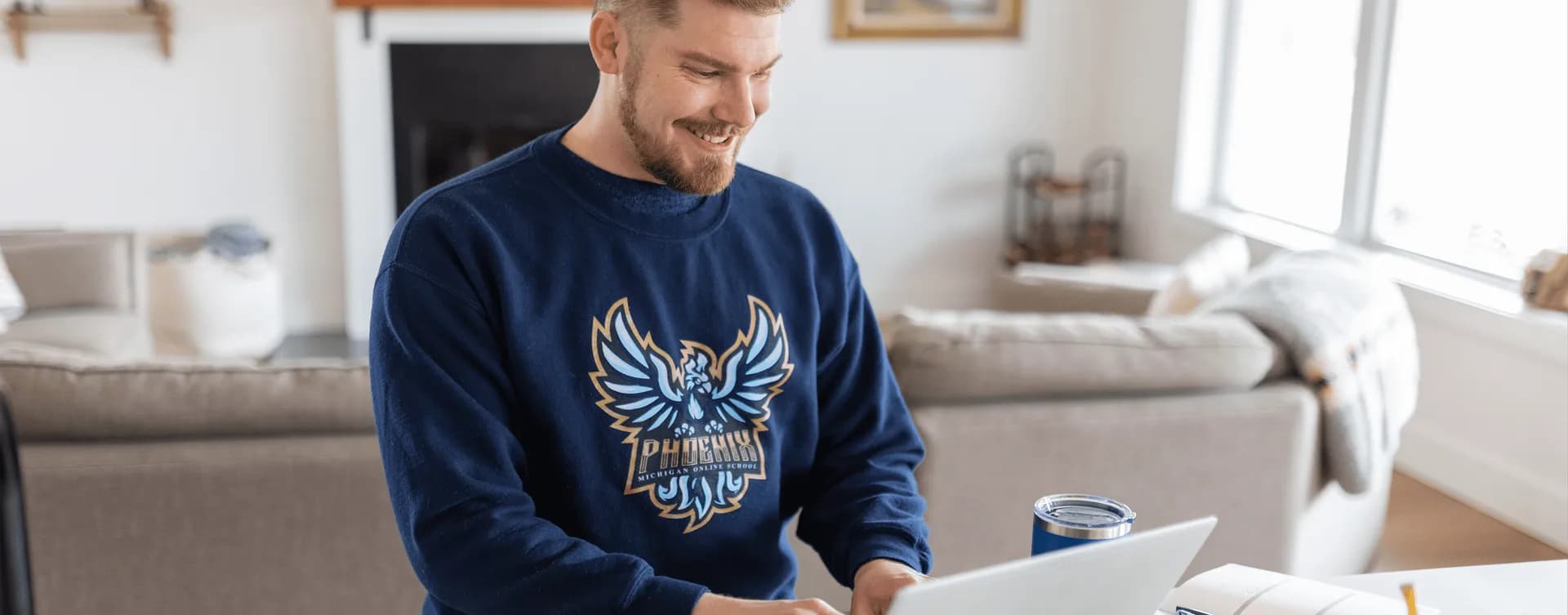 smiling man working on laptop michigan online school about us