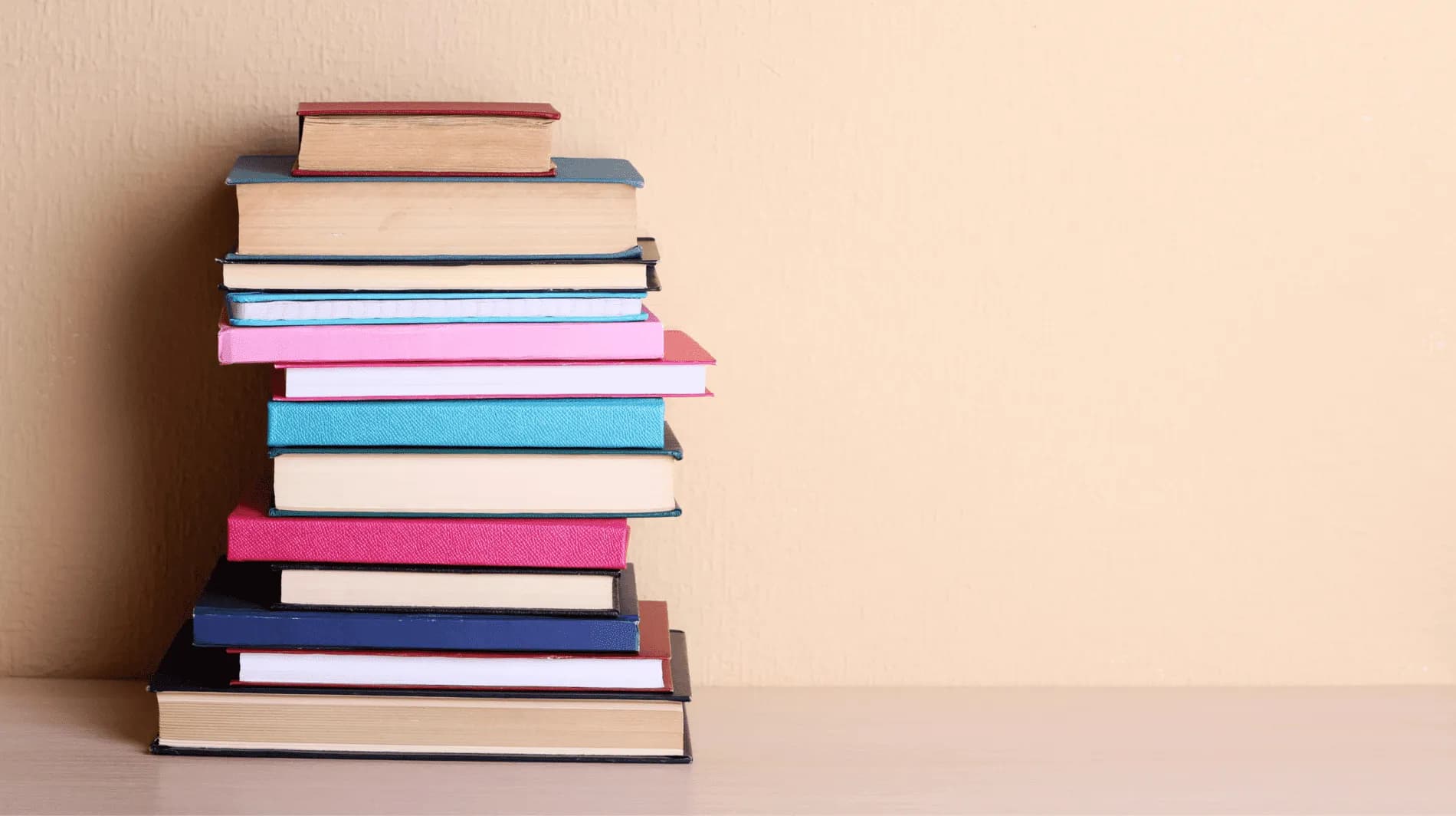our leadership team, stack of books against a peach background